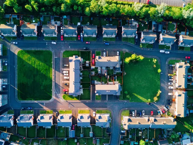 Housing estate with tree-lined greens from above